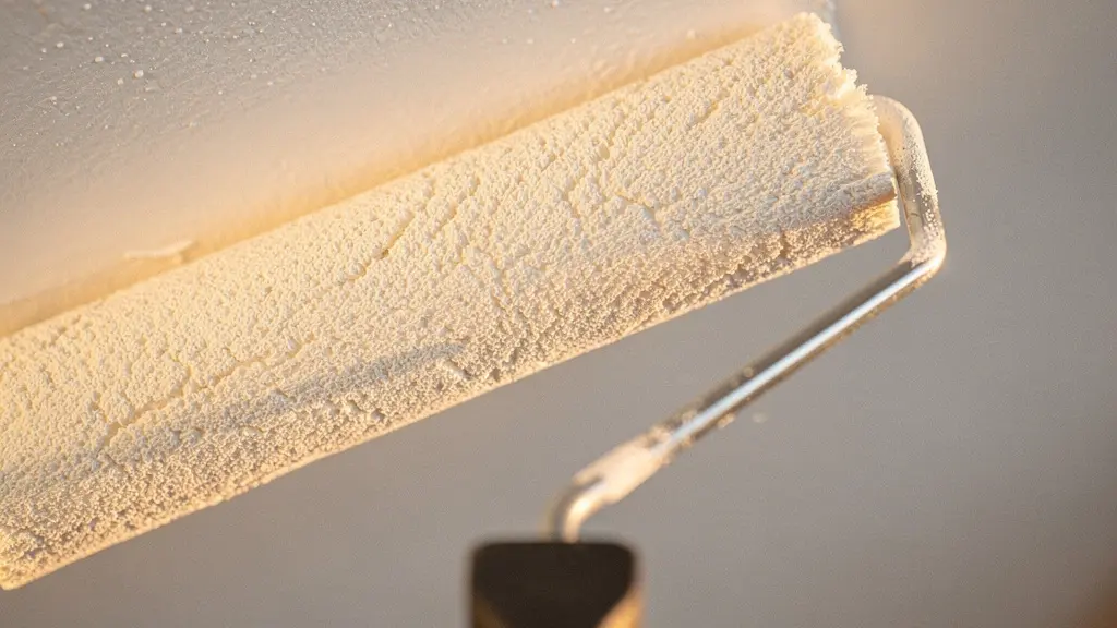 Dettaglio ravvicinato di un rullo di vernice bianca su una parete appena tinteggiata con luce naturale che entra da una finestra, texture della pittura fresca visibile